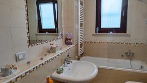 La salle de bains est pourvue d'un lavabo, d'une baignoire et d'un miroir. dans l'établissement Il Giardino di Rosa, à Sammichele di Bari