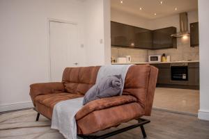 a brown couch with a blanket on it in a kitchen at Enchanting and welcoming space in Aintree
