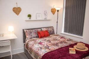 a bedroom with a bed with a hat on it at Enchanting and welcoming space in Aintree