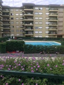 a large apartment building with a swimming pool and flowers at Apartamento Rancho Suizo in Platja d'Aro