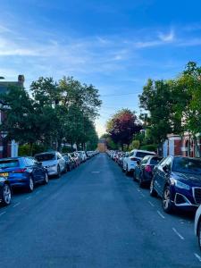 Home in Chiswick Homefields في لندن: شارع فيه سيارات تقف على اطراف الطريق