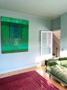 a living room with a couch and a painting on the wall at Home in Chiswick Homefields in London