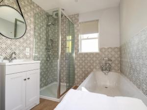 a bathroom with a tub and a shower and a sink at Tresawle in Newquay +20 photos