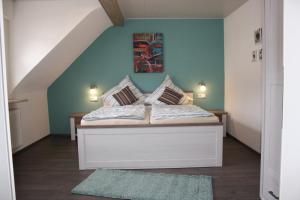 a bedroom with a bed with a blue wall at Ferienwohnung zur Trübenbach in Kirn