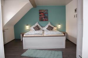 een slaapkamer met een bed met een blauwe muur bij Ferienwohnung zur Trübenbach in Kirn