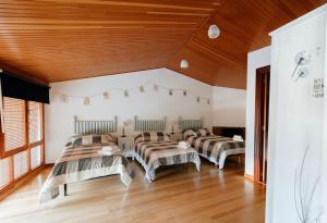 Habitación con 4 camas y techos de madera. en Casa Rural La Lar, en Otero de Bodas