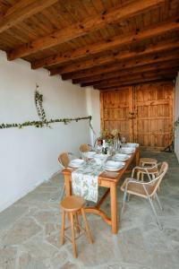 una mesa de madera con sillas y platos. en Casa Rural La Lar, en Otero de Bodas