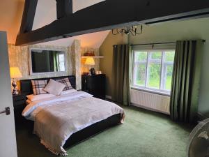 um quarto com uma cama grande e uma janela grande em Mackworth House Farm em Derby