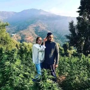 a man and a woman standing on a mountain at Ferme de cannabis à ketama in Tlata Ketama