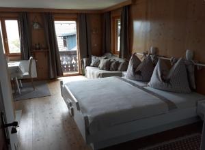 a bedroom with a large white bed and a couch at Haus Hanshois in Millstatt