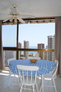 jadalnia ze stołem i krzesłami oraz dużym oknem w obiekcie GEMELOS2 Loysan apt. with pool w mieście Benidorm