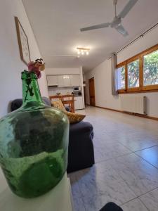 a green glass bottle sitting on a table in a living room at El Penell Apartament Ponent in Vilamaniscle