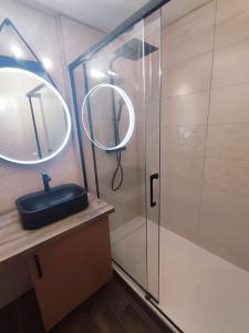 a bathroom with a shower with a black sink and a mirror at L'oasis du château ! "climatisé" in Gréoux-les-Bains