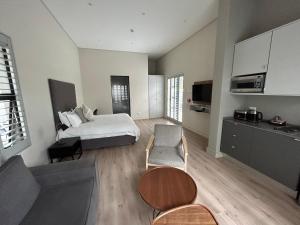 a bedroom with a bed and a living room at The Wantage Suites in Johannesburg