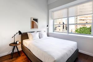 une chambre avec un grand lit blanc et une fenêtre dans l'établissement Kislak 507 Stunning 2BR with Den Corner Apt Retreat Above the City, à Newark