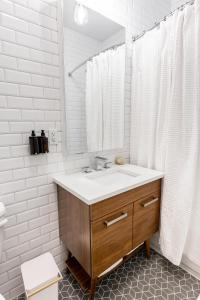 une salle de bain blanche avec un lavabo et un miroir dans l'établissement Kislak 507 Stunning 2BR with Den Corner Apt Retreat Above the City, à Newark