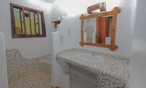a bathroom with a sink and a mirror at Estação Santa Fé Hotel e Pousada in Arraial d'Ajuda