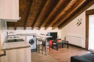 cocina y sala de estar con techos de madera en Apartamentos El Valle en Avín