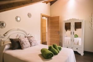 1 dormitorio con cama blanca y almohadas verdes en Apartamentos El Valle en Avín