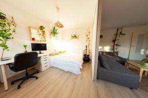 a bedroom with a bed and a desk with a computer at La Cuccia - Fully furnished apartment close to metro and Olympic venues in Châtillon