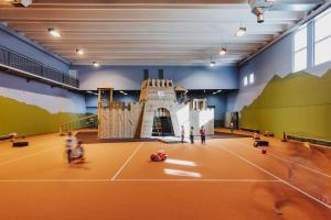 a indoor tennis court with people on it at Familienhotel Lagant in Brand