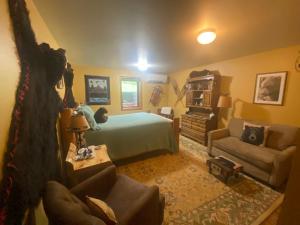 um quarto com uma cama, um sofá e uma cadeira em Two Bears Inn Bed & Breakfast em Red Lodge