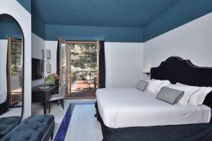 una camera con un grande letto e un balcone di Luxury Suite Royal Positano a Positano