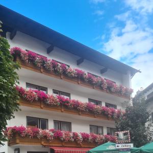 a building with flowers on the side of it at Gasthof Hotel Kirchenwirt in Zell am Ziller