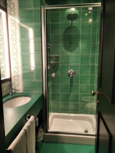 a green tiled bathroom with a shower and a sink at Luxury Suite Royal Positano in Positano