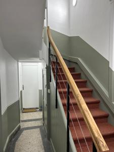 a staircase in a building with a wooden rail at Casa Nostra - Arrière Gare in Arras