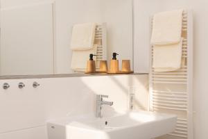 ein weißes Badezimmer mit einem Waschbecken und einem Spiegel in der Unterkunft Ferienwohnung mit malerischem Ausblick in Billerbeck