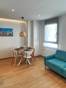 a living room with a table and a blue couch at Coqueto apartamento con garaje in Conil de la Frontera