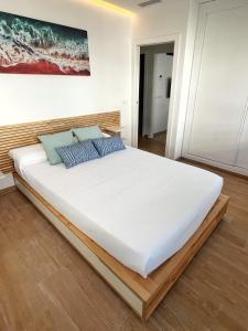 a large white bed with blue pillows in a room at Coqueto apartamento con garaje in Conil de la Frontera