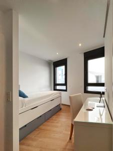 a bedroom with a bed and a desk at Coqueto apartamento con garaje in Conil de la Frontera