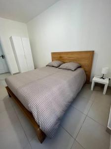 a bedroom with a large bed with a wooden headboard at Bel appartement à 15 min de Lyon in Saint-Fons