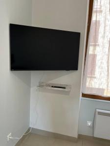a flat screen tv hanging on a wall at Bel appartement à 15 min de Lyon in Saint-Fons