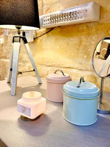 three containers on a counter with a lamp and a light at MCC Suites Valletta in Valletta