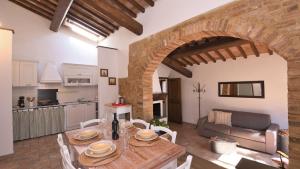 una cucina e un soggiorno con tavolo in legno di Casina di Teo a Monteriggioni