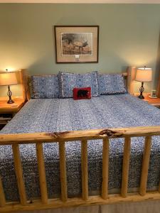 a bed with a blue comforter and two lamps at Two Bears Inn Bed & Breakfast in Red Lodge