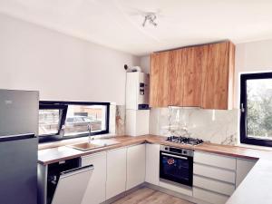 a kitchen with white cabinets and a stove top oven at Express Estates Suceava in Lisaura