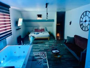 Habitación con bañera, cama y sofá en La Bulle de Romance - Love Room, en Tigy