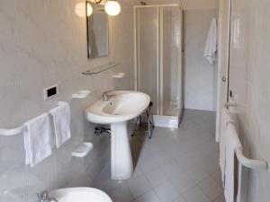 ein weißes Bad mit einem Waschbecken und einer Dusche in der Unterkunft Monte Marsicano Hotel in Pescasseroli
