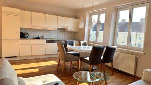 eine Küche mit einem Tisch und Stühlen im Zimmer in der Unterkunft Homely Stay Apartment 3 in Sankt Pölten