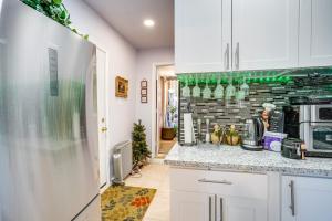 a kitchen with white cabinets and a brick wall at Lush Vallejo Cottage - 20 Mi to Napa Wineries in Vallejo