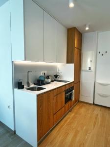 a kitchen with white cabinets and a sink and a refrigerator at Coqueto apartamento con garaje in Conil de la Frontera