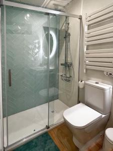 a bathroom with a toilet and a glass shower at Coqueto apartamento con garaje in Conil de la Frontera