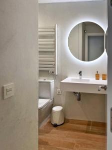 a bathroom with a sink and a toilet and a mirror at Coqueto apartamento con garaje in Conil de la Frontera