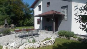 een wit huis met een tafel en stoelen in de tuin bij Kuća za odmor V&E in Bihać
