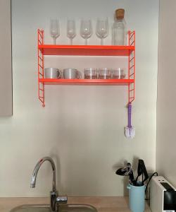 a shelf above a kitchen sink with glasses on it at Briskeby Bliss in Oslo
