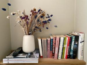 eine Vase auf einem Regal mit Büchern in der Unterkunft Briskeby Bliss in Oslo